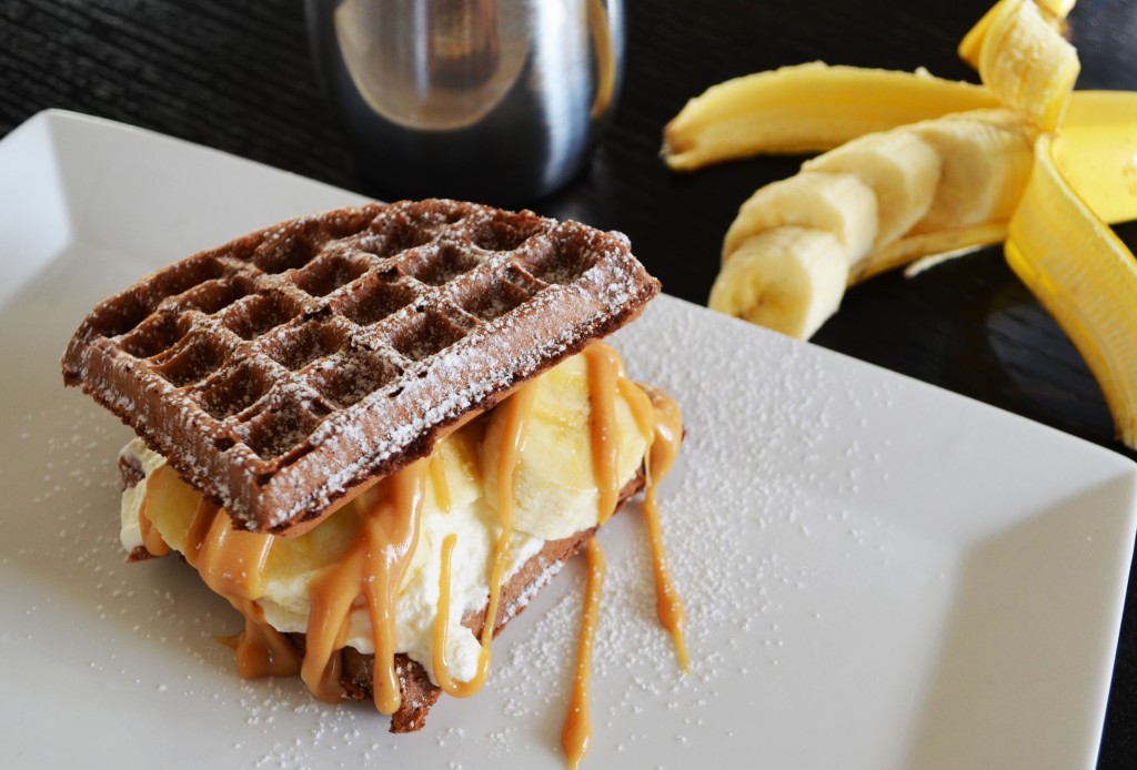 Chocolate Waffle Sandwich with Whipped Cream Bananas and Peanut Butter Drizzle